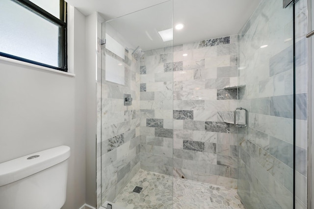 bathroom featuring toilet and an enclosed shower