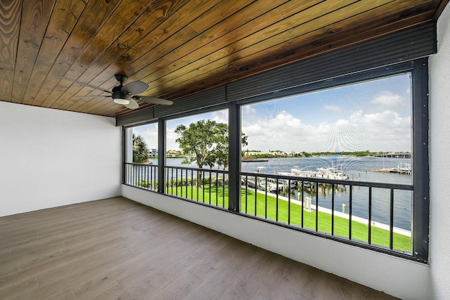 unfurnished sunroom featuring a water view, ceiling fan, and wood ceiling