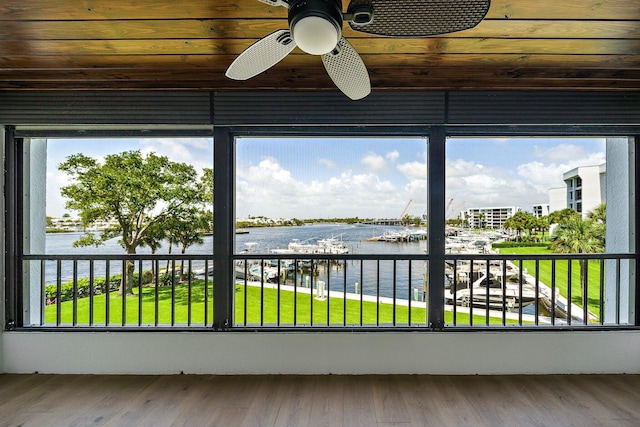 unfurnished sunroom with a water view, ceiling fan, and wooden ceiling