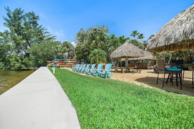 view of property's community featuring a gazebo, a water view, and a lawn