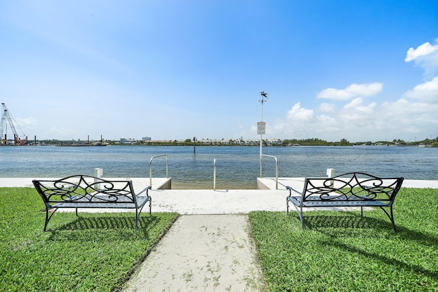 view of property's community with a lawn and a water view