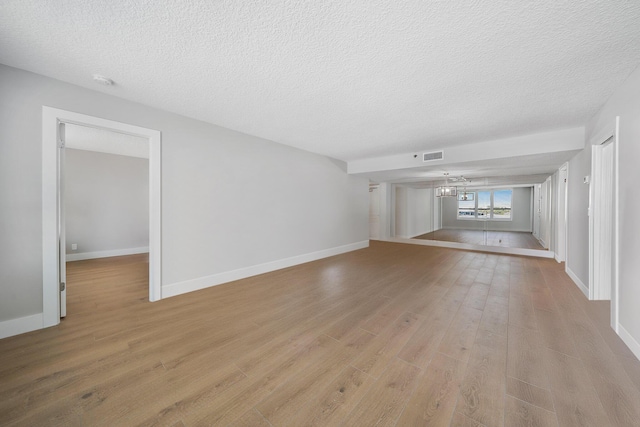 unfurnished living room with light hardwood / wood-style floors and a textured ceiling