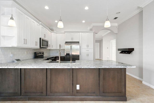 kitchen featuring white cabinetry, stainless steel appliances, light stone counters, and ornamental molding