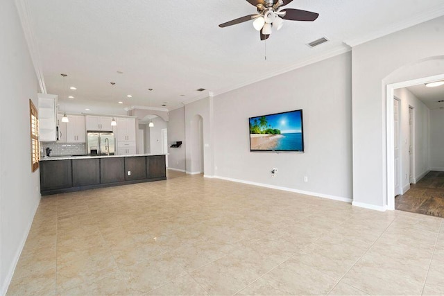 unfurnished living room featuring ceiling fan and ornamental molding