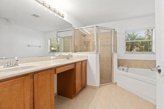 bathroom with tile patterned flooring, vanity, a textured ceiling, and shower with separate bathtub