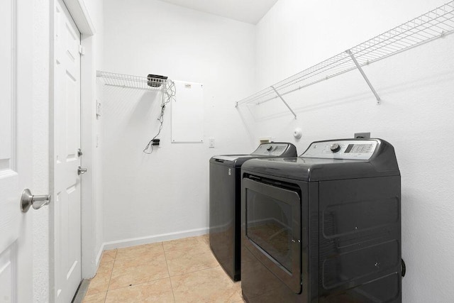 laundry room with washer and dryer and light tile patterned floors