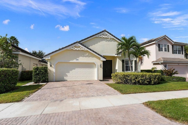 view of front of property with a garage and a front lawn