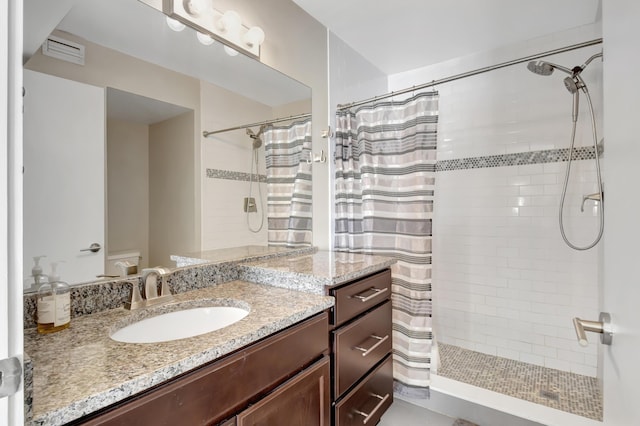 bathroom with toilet, vanity, and walk in shower