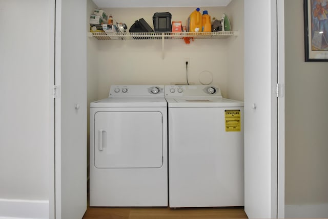 laundry room featuring hardwood / wood-style floors and washing machine and clothes dryer