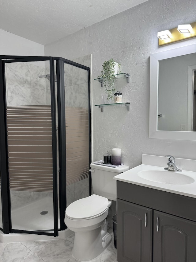 bathroom with vanity, toilet, a shower with door, and a textured ceiling