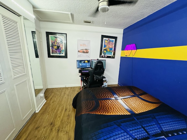 bedroom featuring ceiling fan, a closet, a textured ceiling, and hardwood / wood-style flooring