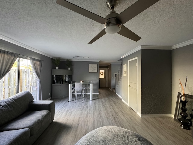 living room featuring wood-type flooring, a textured ceiling, and ceiling fan