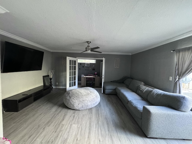 living room featuring a textured ceiling, hardwood / wood-style flooring, ceiling fan, and ornamental molding