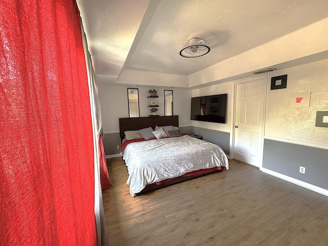 bedroom with a textured ceiling and dark wood-type flooring