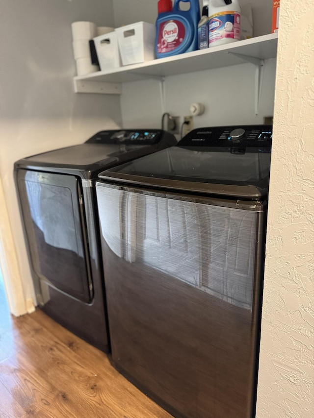 laundry room featuring washer and dryer and hardwood / wood-style flooring