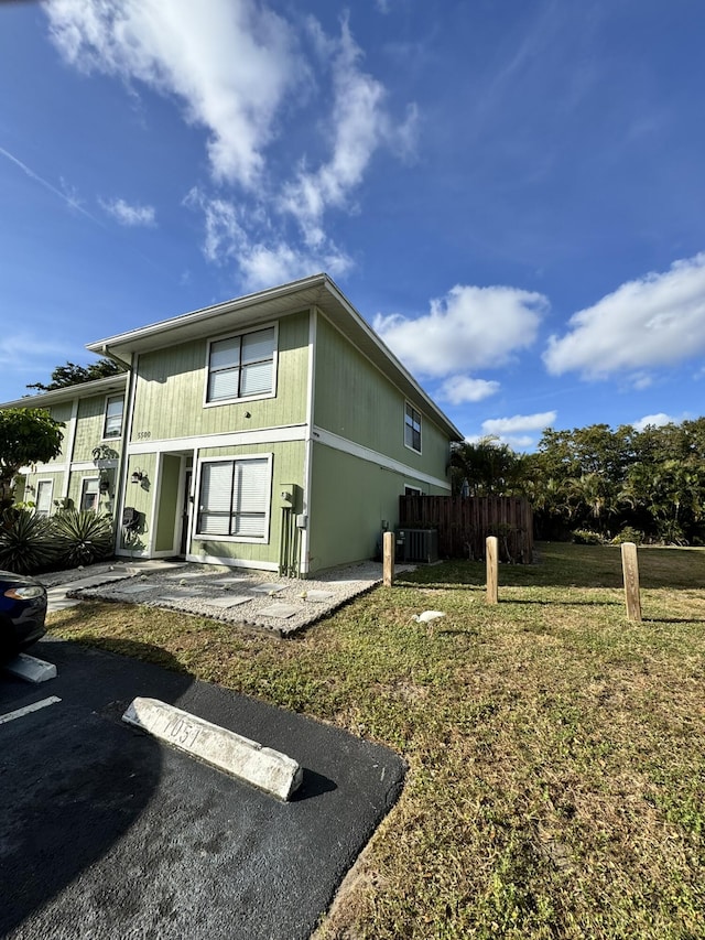 back of house with a lawn and central AC unit