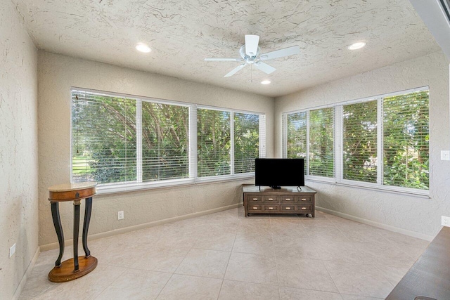 sitting room featuring ceiling fan, light tile patterned floors, and a wealth of natural light