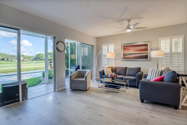 living room with ceiling fan and light hardwood / wood-style flooring