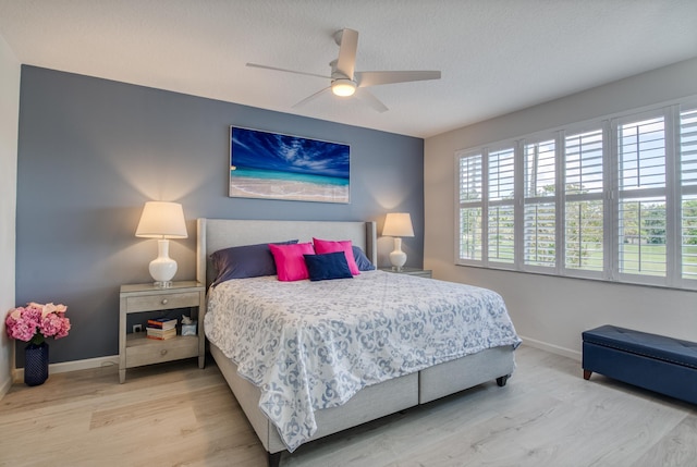 bedroom with wood-type flooring, a textured ceiling, and ceiling fan