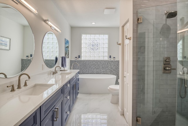 full bathroom featuring separate shower and tub, vanity, and toilet