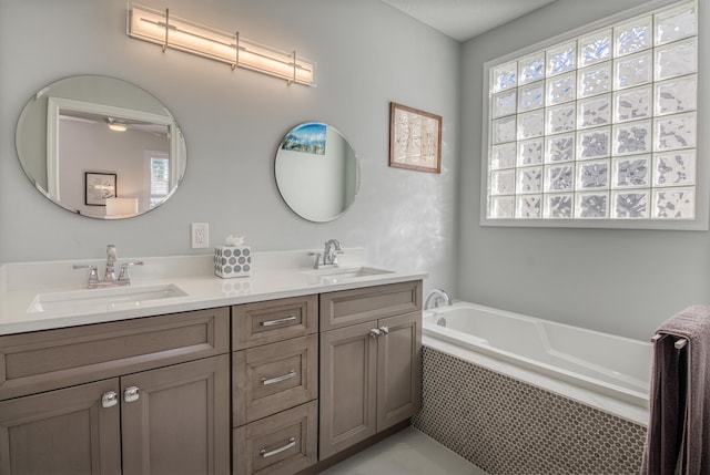 bathroom with vanity and tiled tub