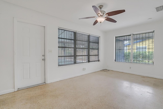 empty room featuring baseboards, visible vents, and a ceiling fan