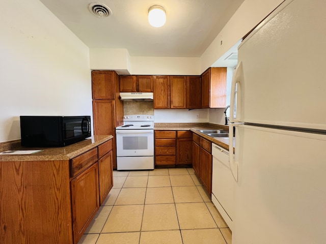 kitchen featuring sink, white appliances, and light tile patterned flooring