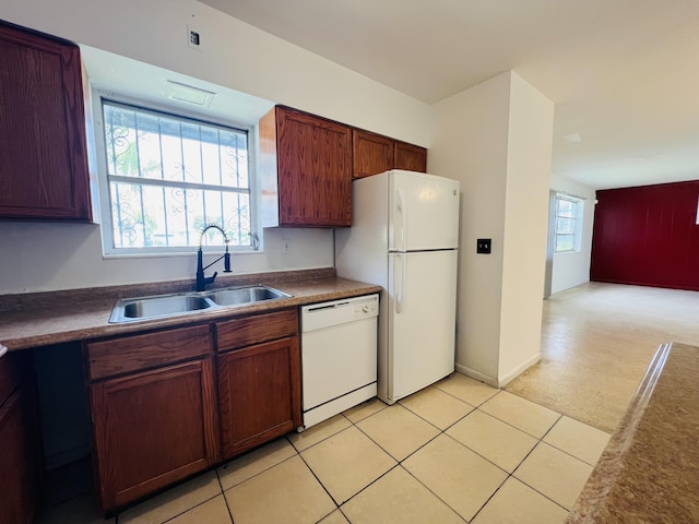 kitchen with white appliances, sink, and light carpet