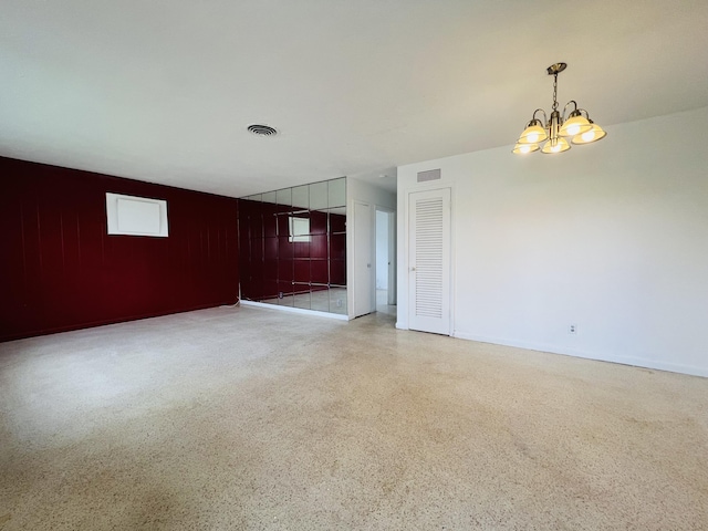 spare room featuring an inviting chandelier