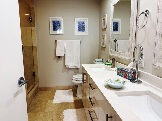 bathroom featuring toilet, vanity, and tiled shower