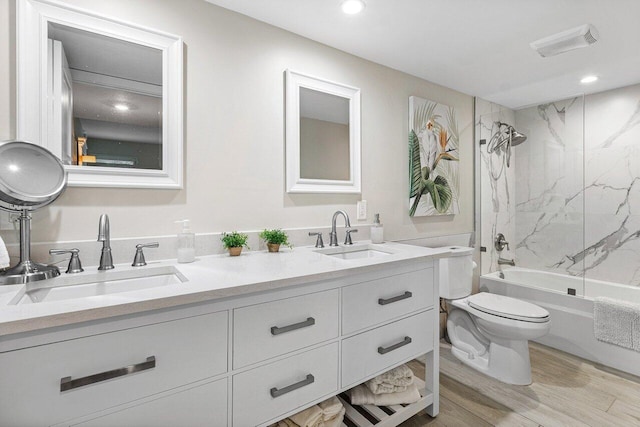 full bathroom with vanity, toilet, wood-type flooring, and tiled shower / bath