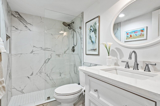 bathroom featuring a tile shower, vanity, and toilet