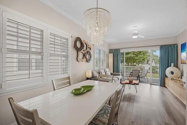 dining space with ornamental molding, hardwood / wood-style floors, and ceiling fan with notable chandelier