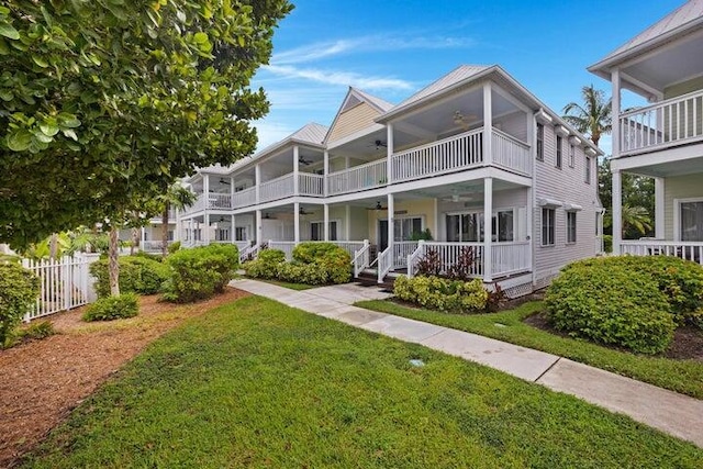 view of front facade featuring ceiling fan, a front yard, and covered porch