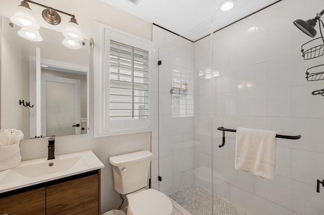 bathroom with toilet, an enclosed shower, and vanity