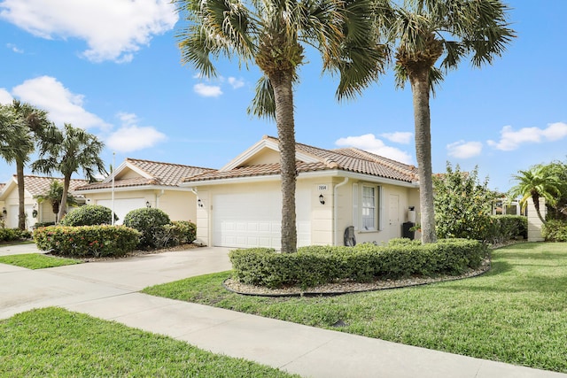 mediterranean / spanish-style house featuring a front yard and a garage