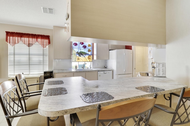 kitchen with tasteful backsplash, sink, light tile patterned flooring, and white appliances