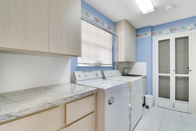 laundry room with cabinets, sink, separate washer and dryer, a textured ceiling, and light tile patterned floors