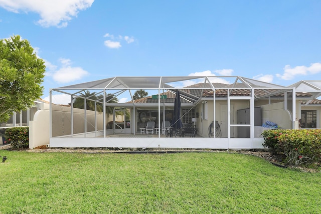 back of property featuring glass enclosure and a yard