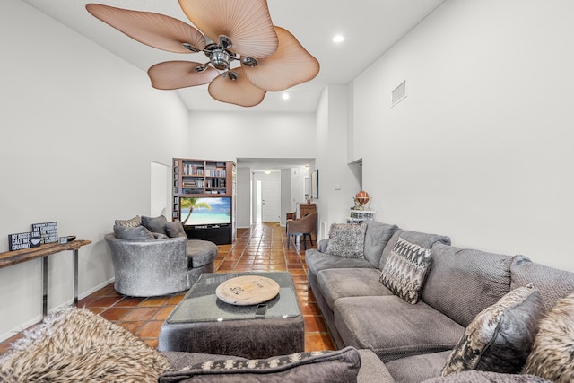 tiled living room featuring ceiling fan and high vaulted ceiling