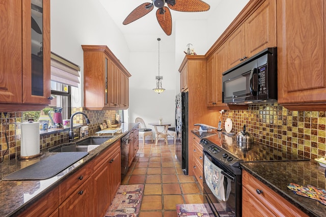 kitchen featuring sink, dark stone counters, pendant lighting, decorative backsplash, and black appliances