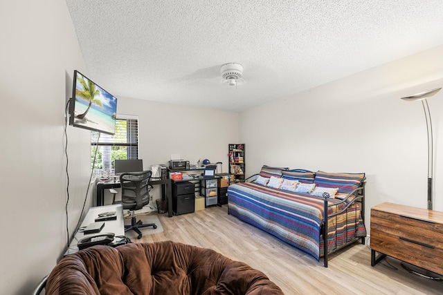 bedroom featuring light wood-type flooring and a textured ceiling