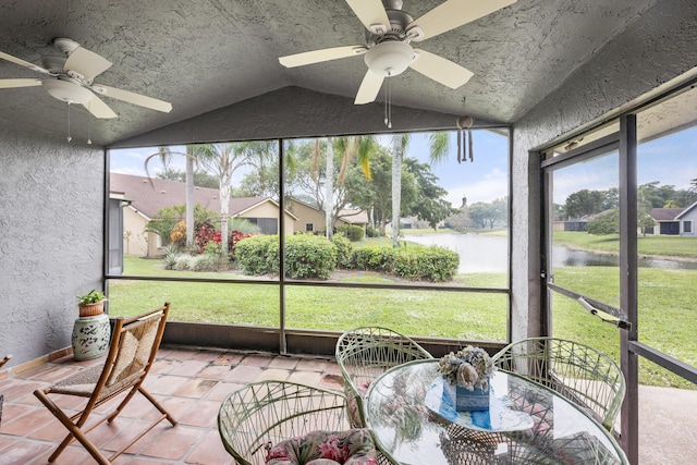 sunroom with ceiling fan, a water view, and lofted ceiling