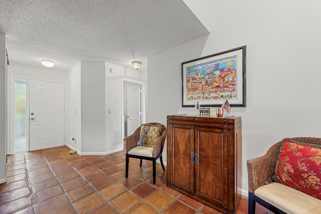 sitting room with tile patterned flooring and a textured ceiling