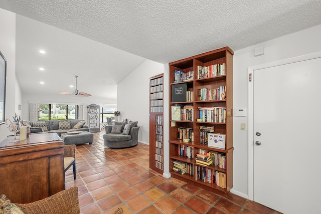 tiled living room featuring a textured ceiling, ceiling fan, and lofted ceiling