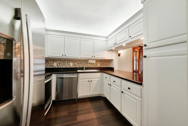 kitchen with sink, dark wood-type flooring, decorative backsplash, white cabinets, and appliances with stainless steel finishes