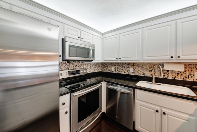 kitchen with backsplash, sink, white cabinets, and appliances with stainless steel finishes