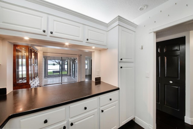 kitchen with a textured ceiling and white cabinetry