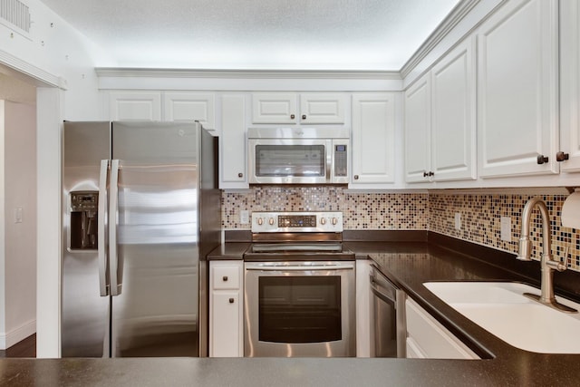 kitchen with white cabinets, stainless steel appliances, tasteful backsplash, and sink