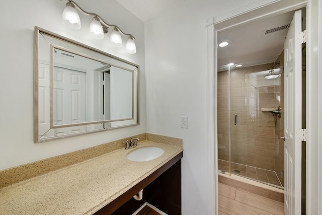 bathroom featuring vanity and an enclosed shower